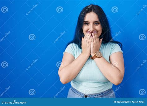 Young Modern Girl With Blue Hair Standing Over Blue Background Laughing And Embarrassed Giggle