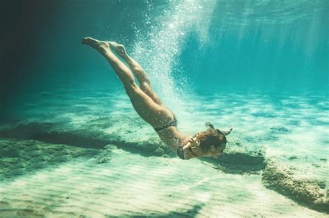 Hermosa Joven Sonriente Nadando Bajo El Agua En El Mar Foto Premium