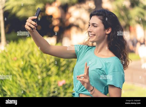 Portrait Of Laughing Young Woman Taking Selfie With Smartphone Hi Res