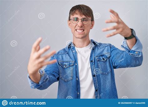 Caucasian Blond Man Standing Wearing Glasses Shouting Frustrated With