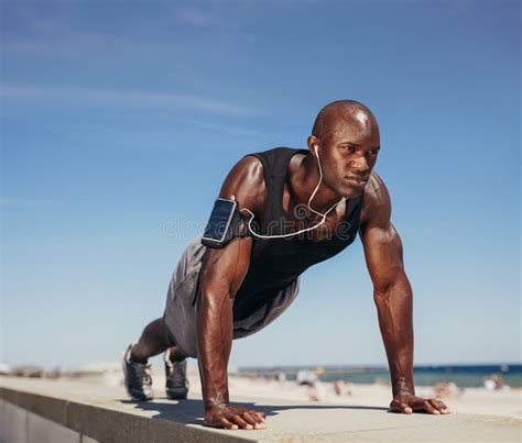 Hombre Muscular Que Hace Pectorales Contra El Cielo Azul Foto De