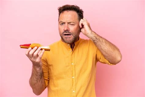 Hombre caucásico de mediana edad sosteniendo sashimi aislado de fondo