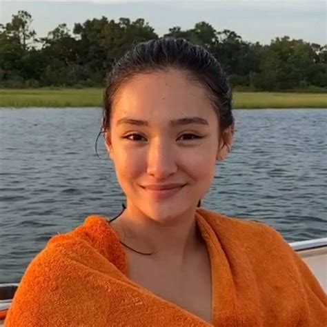 A Woman Sitting In A Boat With An Orange Towel On Her Shoulders