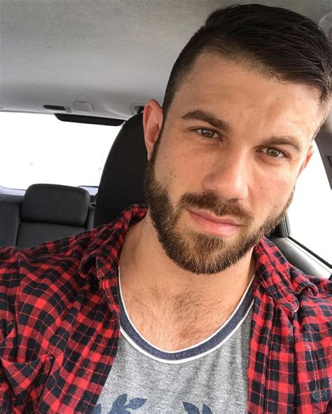 A Man With A Beard Sitting In The Back Seat Of A Car Looking At The Camera