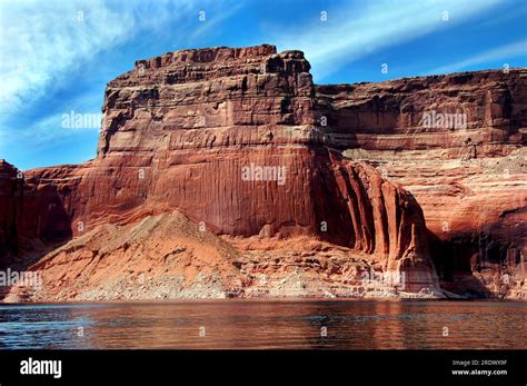 Red Sandstone Cliff Reaches For Blue Sky Along The Shores Of Lake