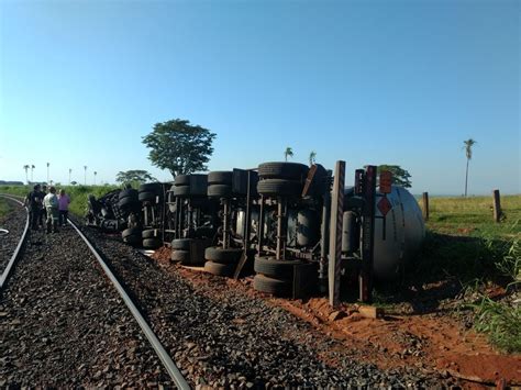 Caminhão tanque carregado de etanol tomba após ser atingido por trem em