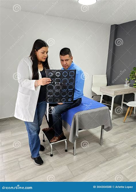 Doctor Latina Neurologist Attends To Male Brunette Patient Shows Brain X Ray To Evaluate