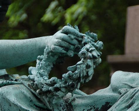 Hand Holding Out A Wreath Verdigris Statue On Grave Monument A