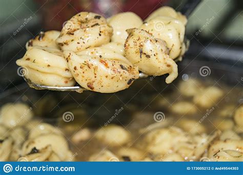 Boiled Dumplings With Spices On A Spoon Over A Pot Of Cooked Dumplings