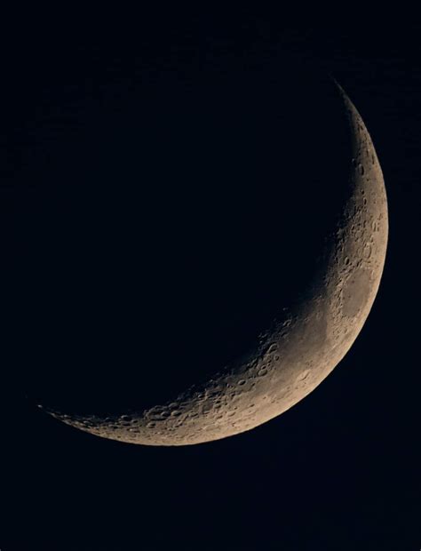 The Crescent Moon Is Seen In The Dark Night Sky With Only One Half Visible