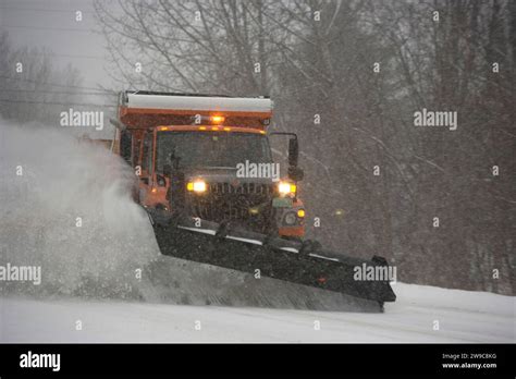 Heavy Duty Snowplow Clearing A Rural Road During A Winter Blizzard In