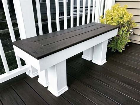 A White Bench Sitting On Top Of A Wooden Deck Next To A Planter Filled