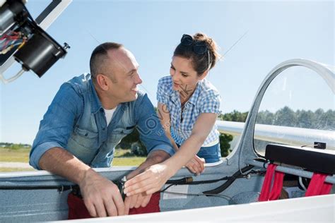 Pilot Smiling Inviting Girlfriend Aboard Private Airplane In Picture