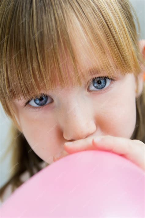 Mignon Petite Fille Gonflant Un Ballon Rose Dans La Cuisine Photo