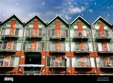 Straight View Of A Red Brick And Green Wood Three Stacked Apartment