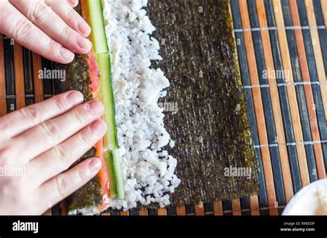 Making Sushi Rolls At Home Female Hands Roll Nori Seaweed Sheet On A