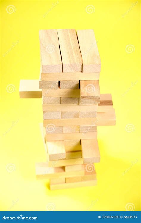 Blocks Of The Wooden Game Jenga On A Yellow Background Space For Text