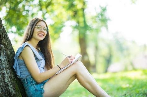 Jeune Femme Assise Et Lisant Son Livre Préféré Sur Ao Green Gras Sous L