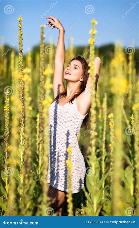 Young Brunette Woman In White Dress Standing With Eyes Closed And