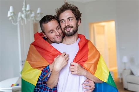 Casal gay masculino carinhoso dentro de casa Homem abraçando seu namorado por trás em casa Casal