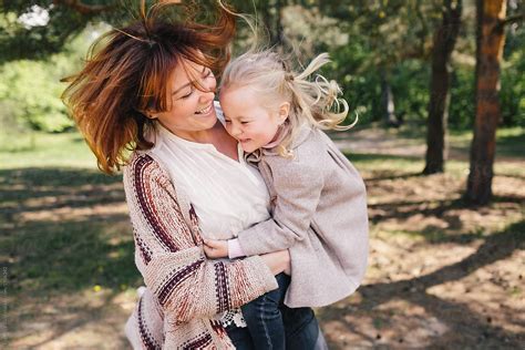 Mother And Daughter Playing Under The Pines By Stocksy Contributor