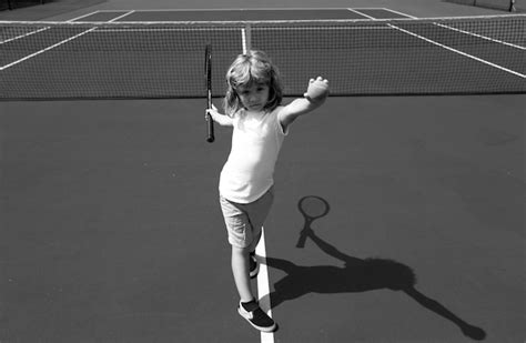 Un Niño Lindo Jugando Al Tenis En La Cancha Foto Premium