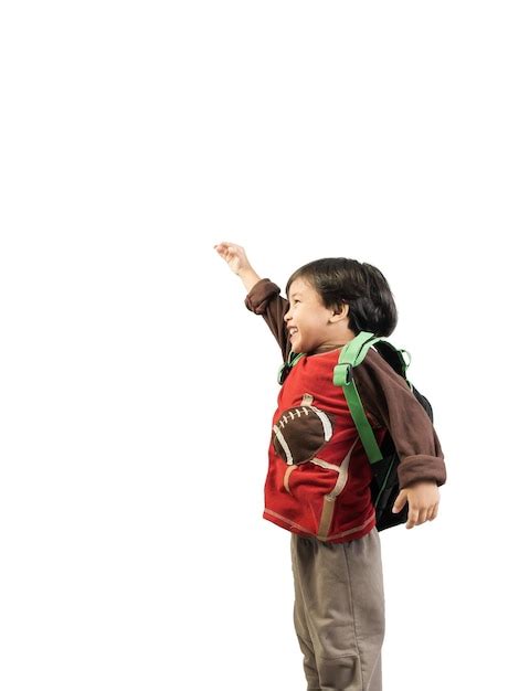 Niño sonriente con los brazos levantados de pie contra un fondo blanco