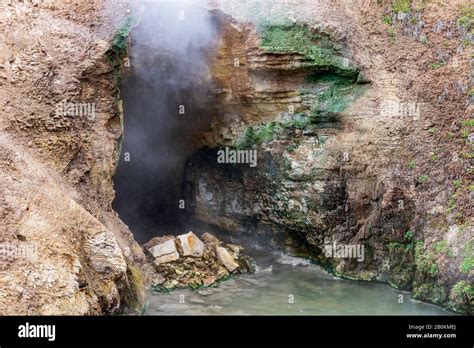 Cave Entrance With Steam And Gas Coming Out Hot Spring At Entrance To