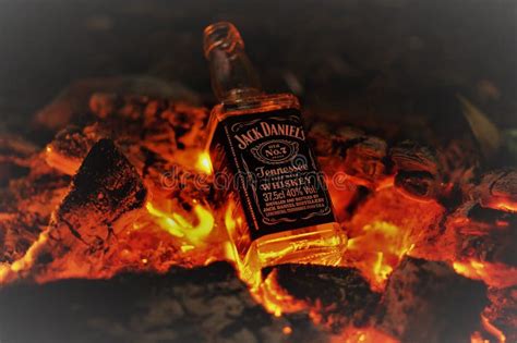 Bottle Of Whiskey Jack Daniel`s On Fire With Burning Charcoals In The Night Editorial Stock