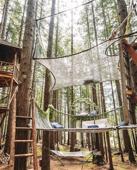 A Tree House In The Woods With Hammocks Hanging From It S Sides