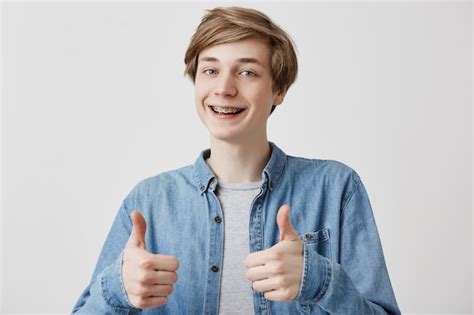 Retrato Del Hombre Joven Feliz Con El Pelo Rubio Que Da Dos Pulgares