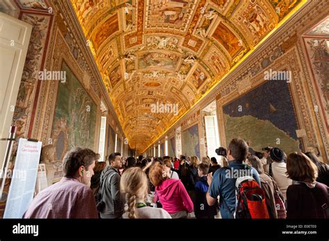 Turistas mirando el ornamentado techo decorado la Galería de los mapas