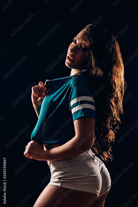 Sideways Portrait Of Beautiful Brunette Woman In Short Shorts And Blue