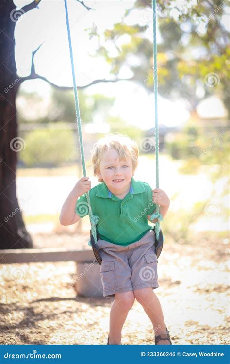 Little Blonde Boy Playing On Swing At Preschool For Kindy Portraits