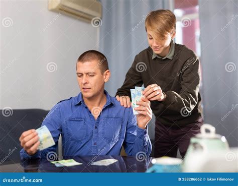 Padre Dando A Su Hijo Adolescente Dinero De Bolsillo Foto De Archivo