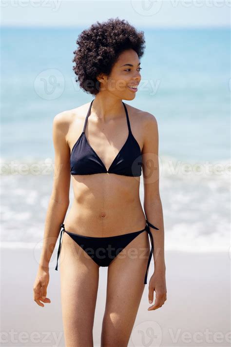 Femme Noire Positive En Bikini Marchant Sur La Plage En Souriant Photo De Stock Chez