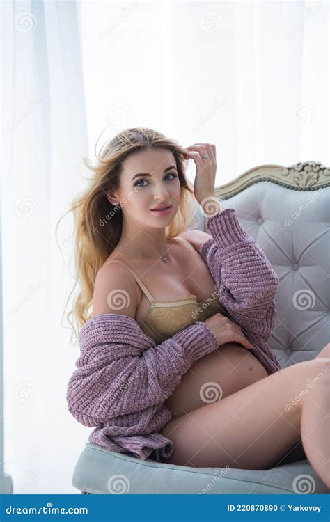 A Pregnant Blonde Woman Is Sitting In A Vintage Beige Armchair Close Up Stock Photo Image Of