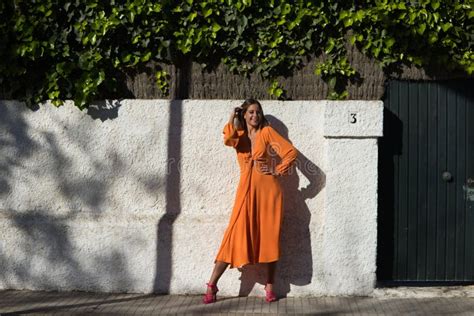 Jolie Jeune Femme Blonde En Robe Orange Pose Pour Des Photos Sur Mur