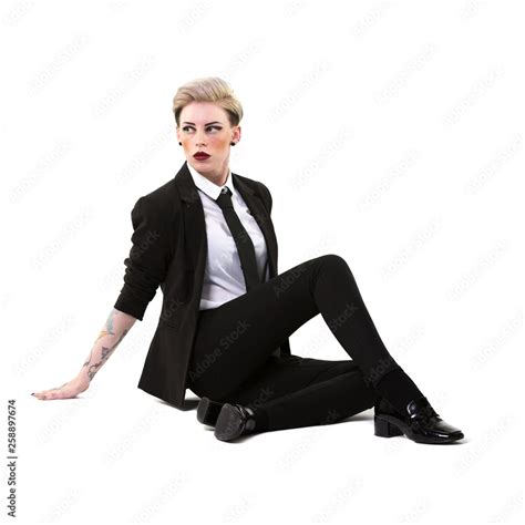 Short Haired Blonde Woman Sitting On The Floor Wearing A Suit Shirt And Tie Isolated On A