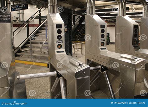 The Turnstile Of A Subway Station With People Passing Through Public