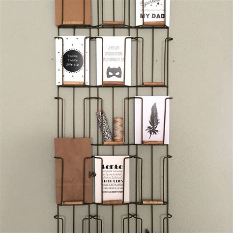 There Is A Metal Shelf With Books On It And Some Other Items In The Holder