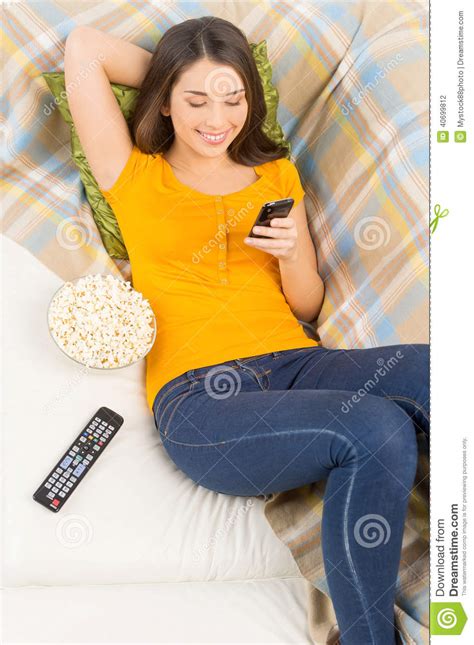 Belle Brune Se Trouvant Sur Le Sofa Et Textoter Photo Stock Image Du