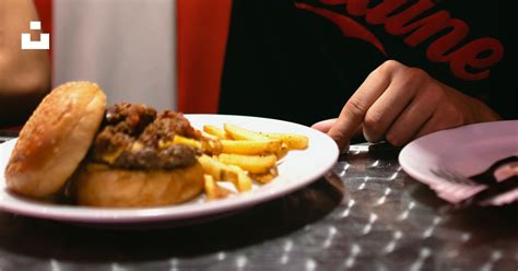 Homme Versant De La Sauce Sur Un Hamburger Et Des Frites Photo Photo