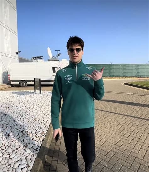 A Man In Green Jacket And Sunglasses Standing On Brick Walkway Next To