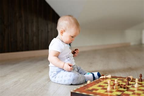 Dois Bebês Menino E Menina Que Jogam A Xadrez No Assoalho De Madeira