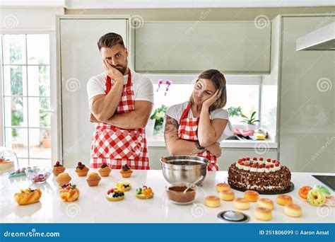 Young Couple Cooking Pastries At The Kitchen Thinking Looking Tired And Bored With Depression