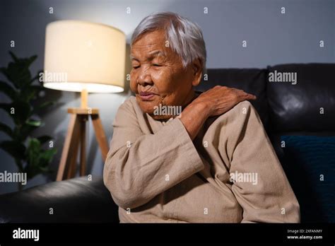 Senior Woman Suffering From Neck And Shoulder Pain While Sitting On A