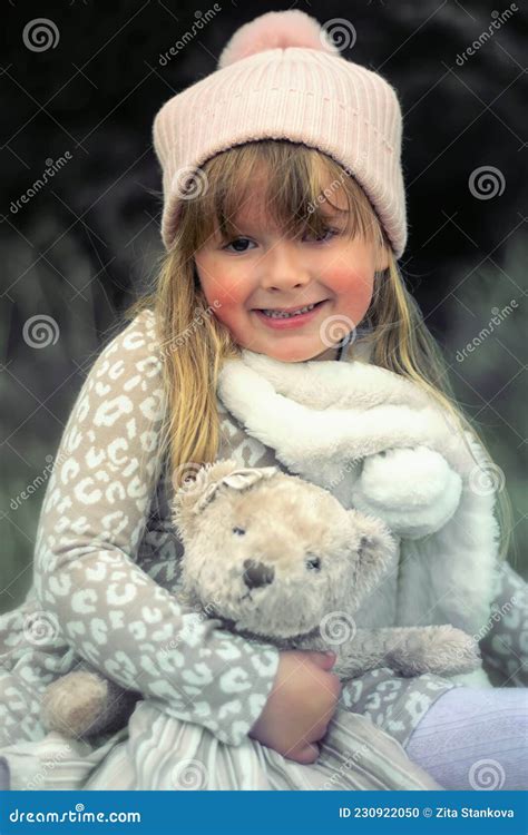 Petite Fille Assise Sur Un Banc Avec Un Ours En Peluche Photo Stock