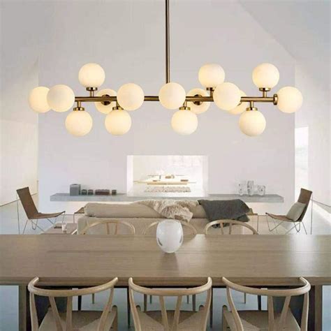 A Dining Room Table With Chairs And Lights Hanging From It S Ceiling