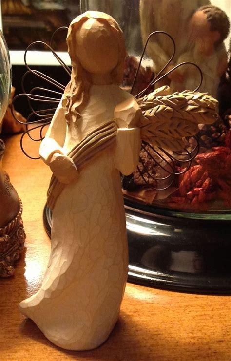 An Angel Figurine Sitting On Top Of A Table Next To A Glass Dome